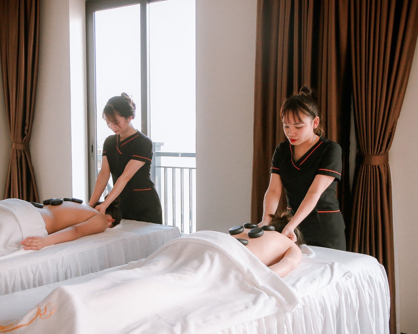 Hot stone massage treatment in progress at Aura spa