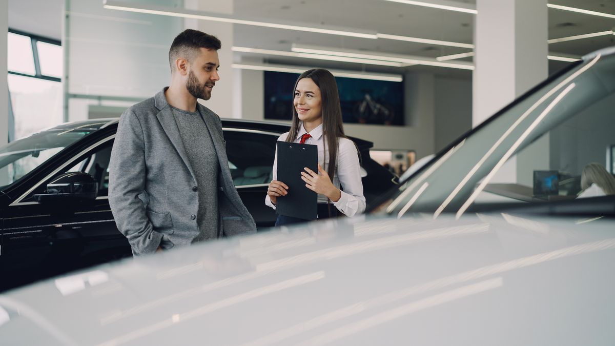 A car sales consultant reviewing paperwork with a customer