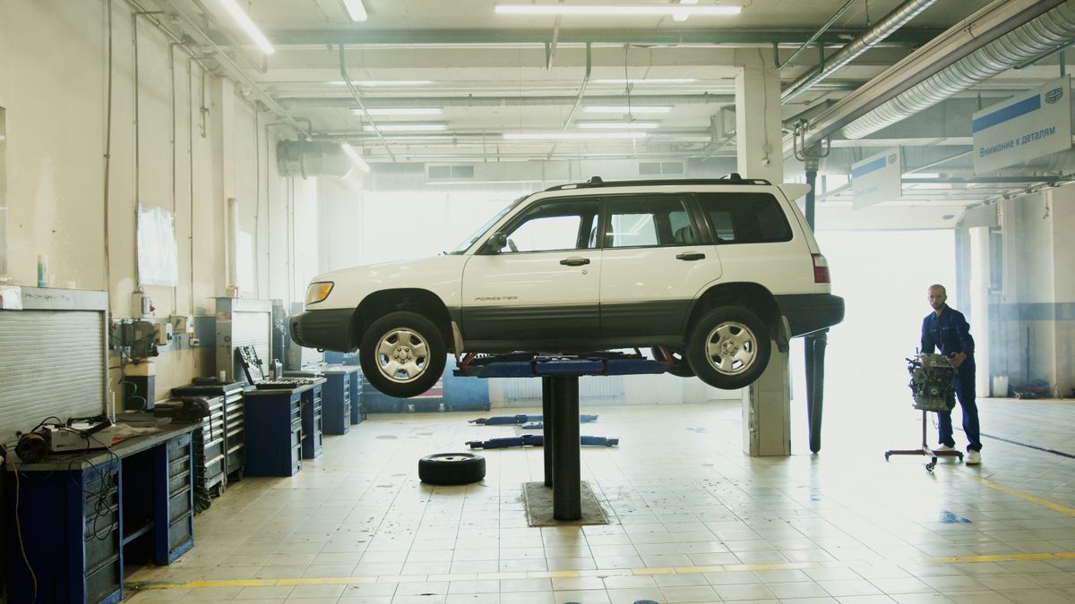 An SUV raised on a lift in a vehicle service workshop