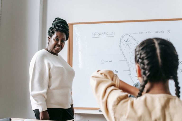A teacher and a child working together at a whiteboard