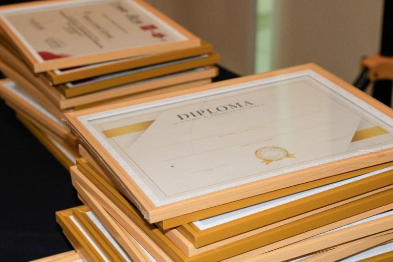 A stack of framed diplomas and certificates