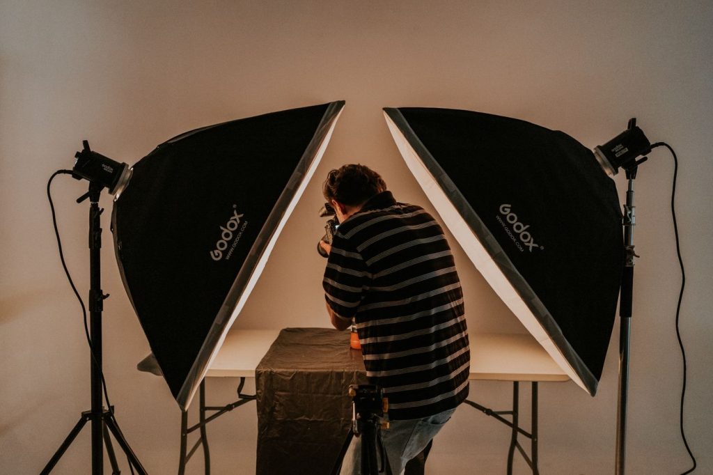 A photographer working in a studio between two softbox lights