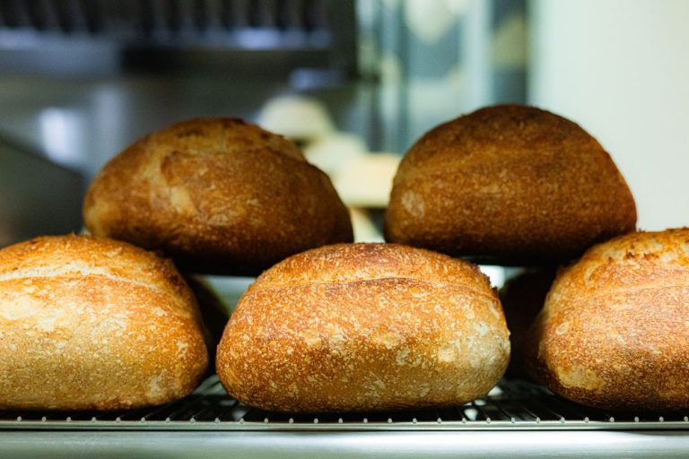 Golden loaves of freshly baked bread cooling on a rack
