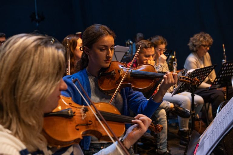 Young string players rehearsing together in an orchestra