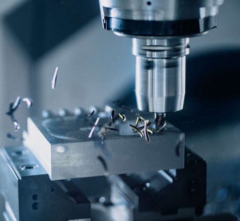 A CNC milling machine cutting a block of metal
