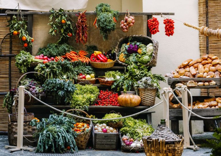 A farm shop stall piled with fresh vegetables and produce
