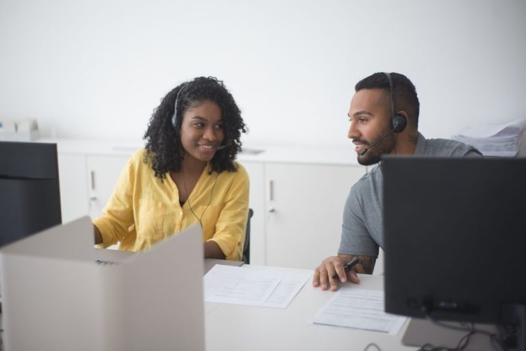 Two colleagues at a desk in a support team office