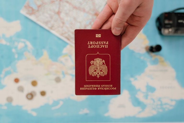 A hand holding a passport over a map