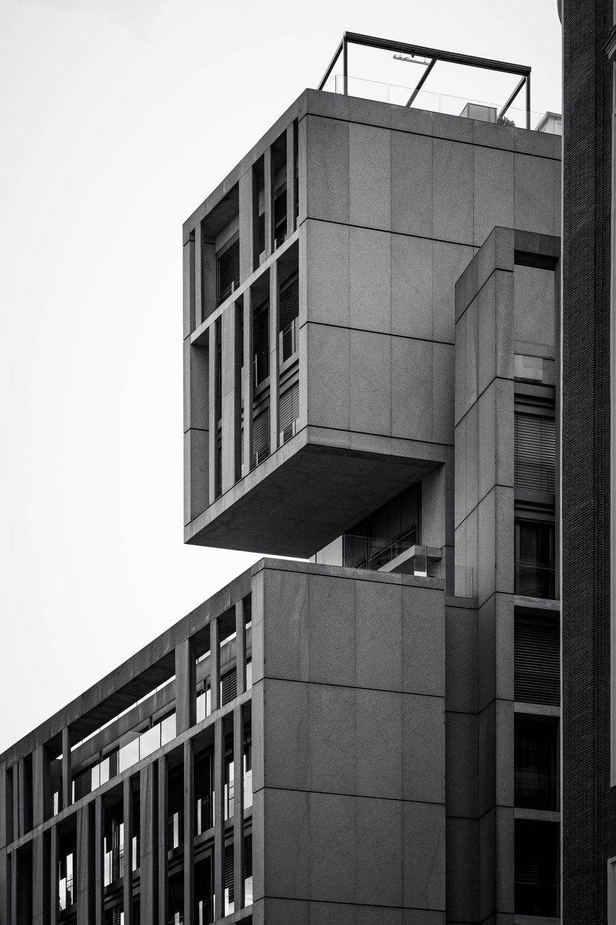 A stacked concrete office building with terraces