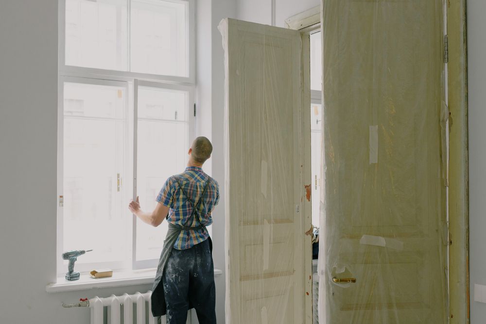 A tradesman fitting a door frame in a renovated room