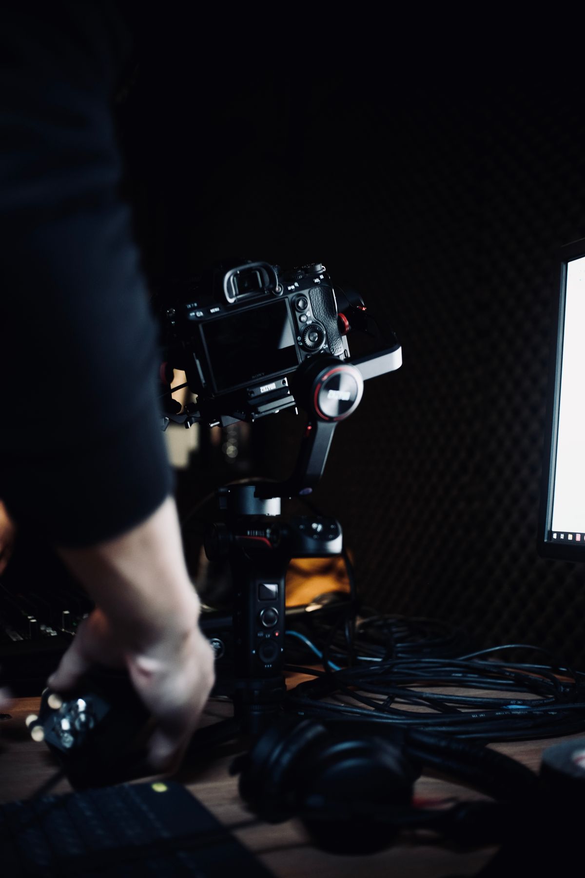 A film camera on a rig in a dark studio