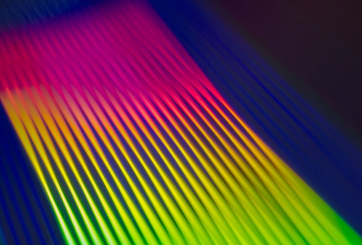 Diagonal bands of pink, yellow and green light