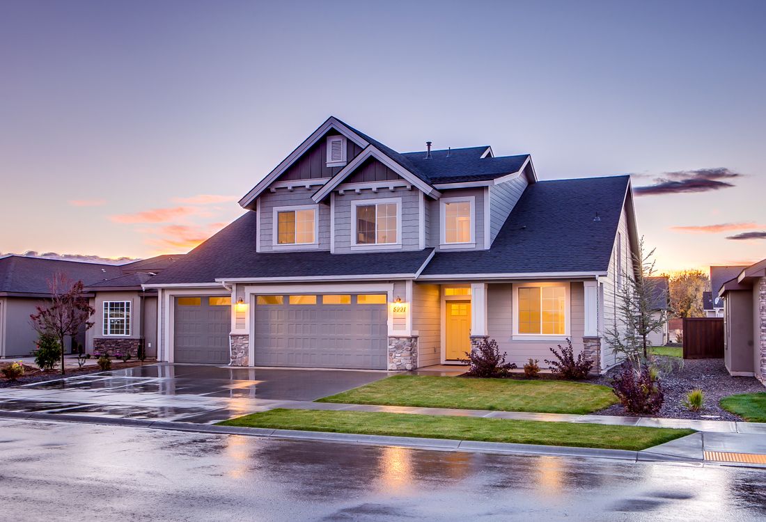 A two-storey family home with a double garage at dusk