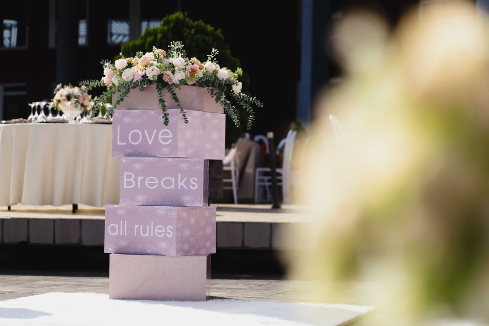 A floral welcome sign at an outdoor wedding reception
