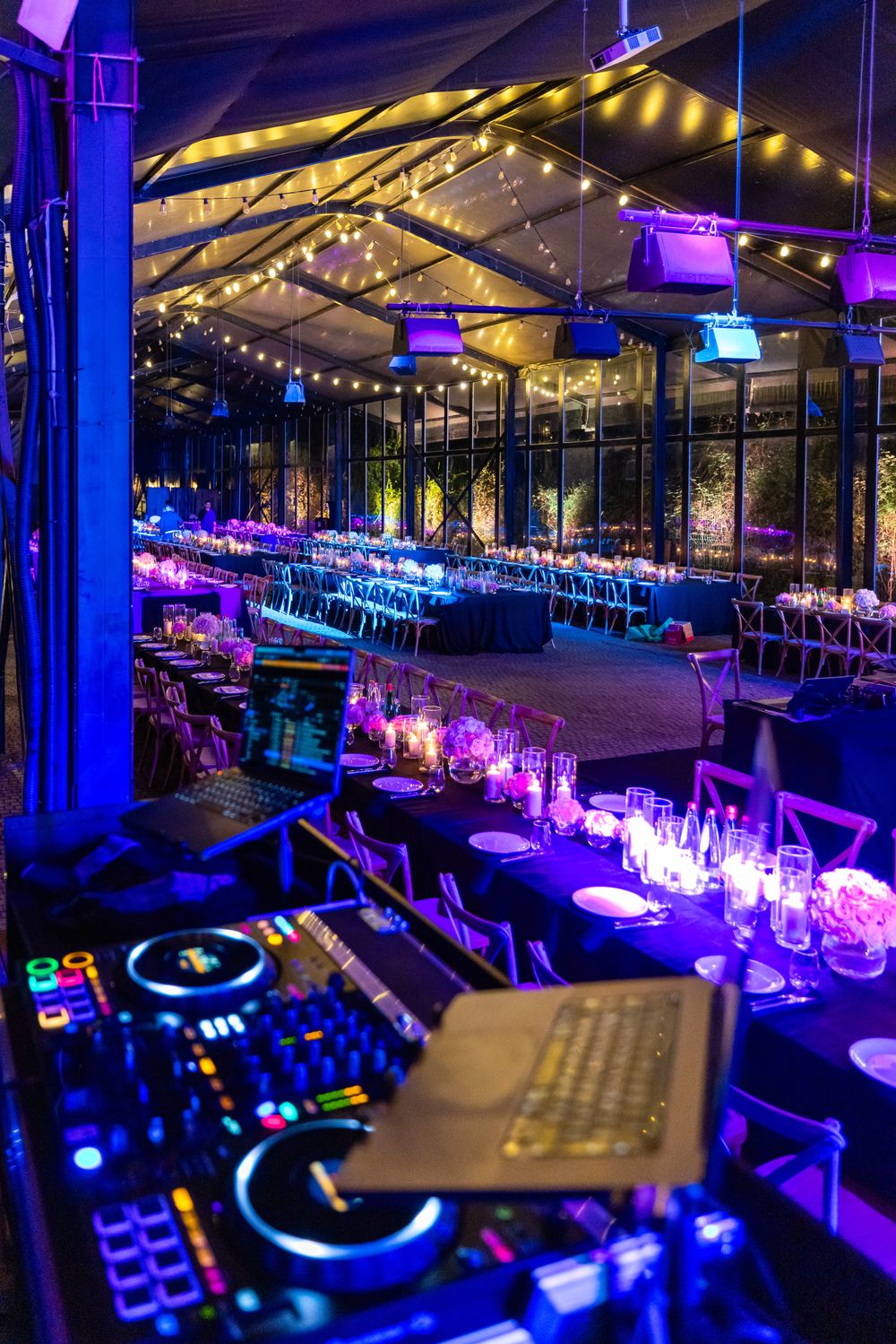 A lit stage with a DJ set at an evening corporate event