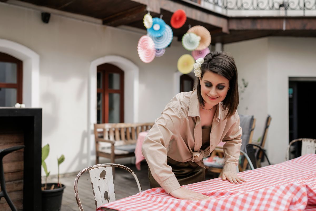 An event stylist arranging table linen ahead of a celebration