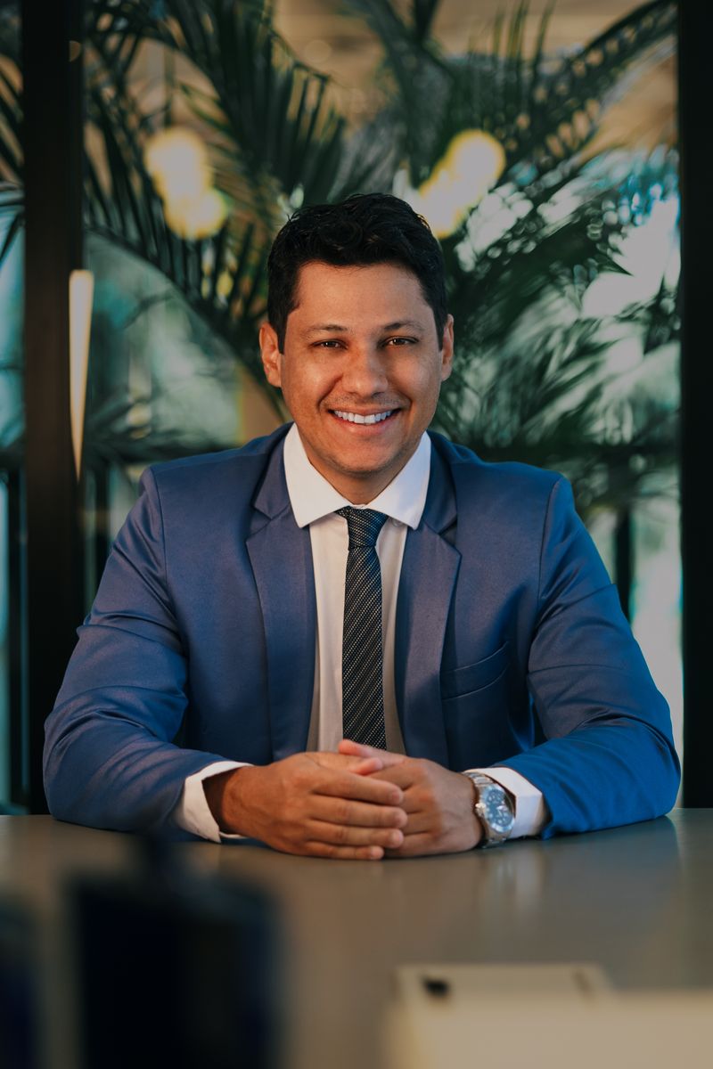 Rafael Ortiz, Business Adviser, in a blue suit at a table