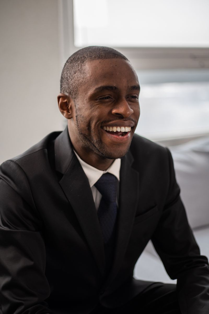 Daniel Mensah, Protection Specialist, laughing in a dark suit