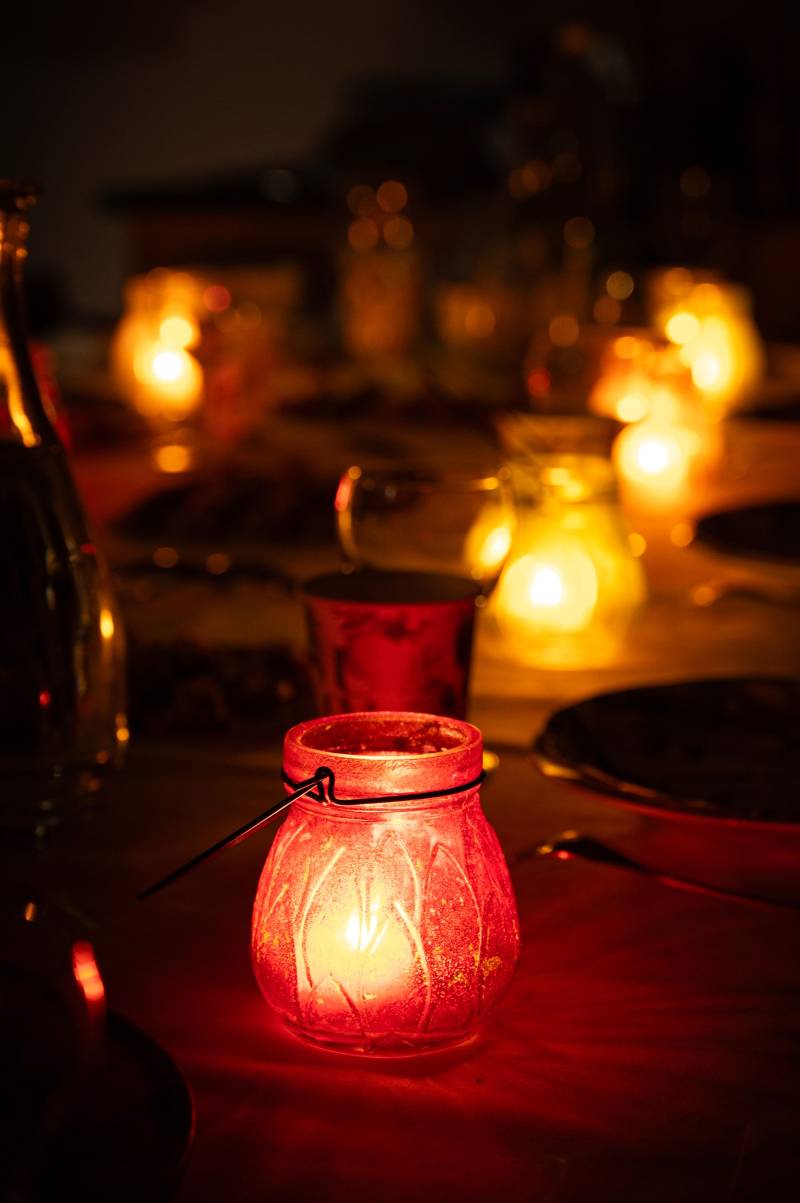 A red glass lantern glowing on a dinner table at night