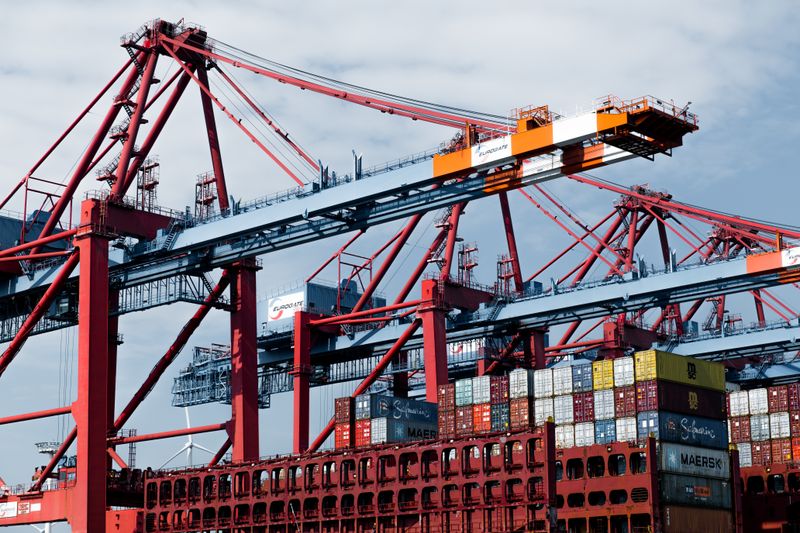 Red container cranes above stacked shipping containers