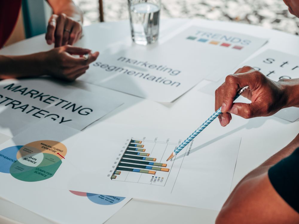 Hand pointing at a marketing strategy chart on a table