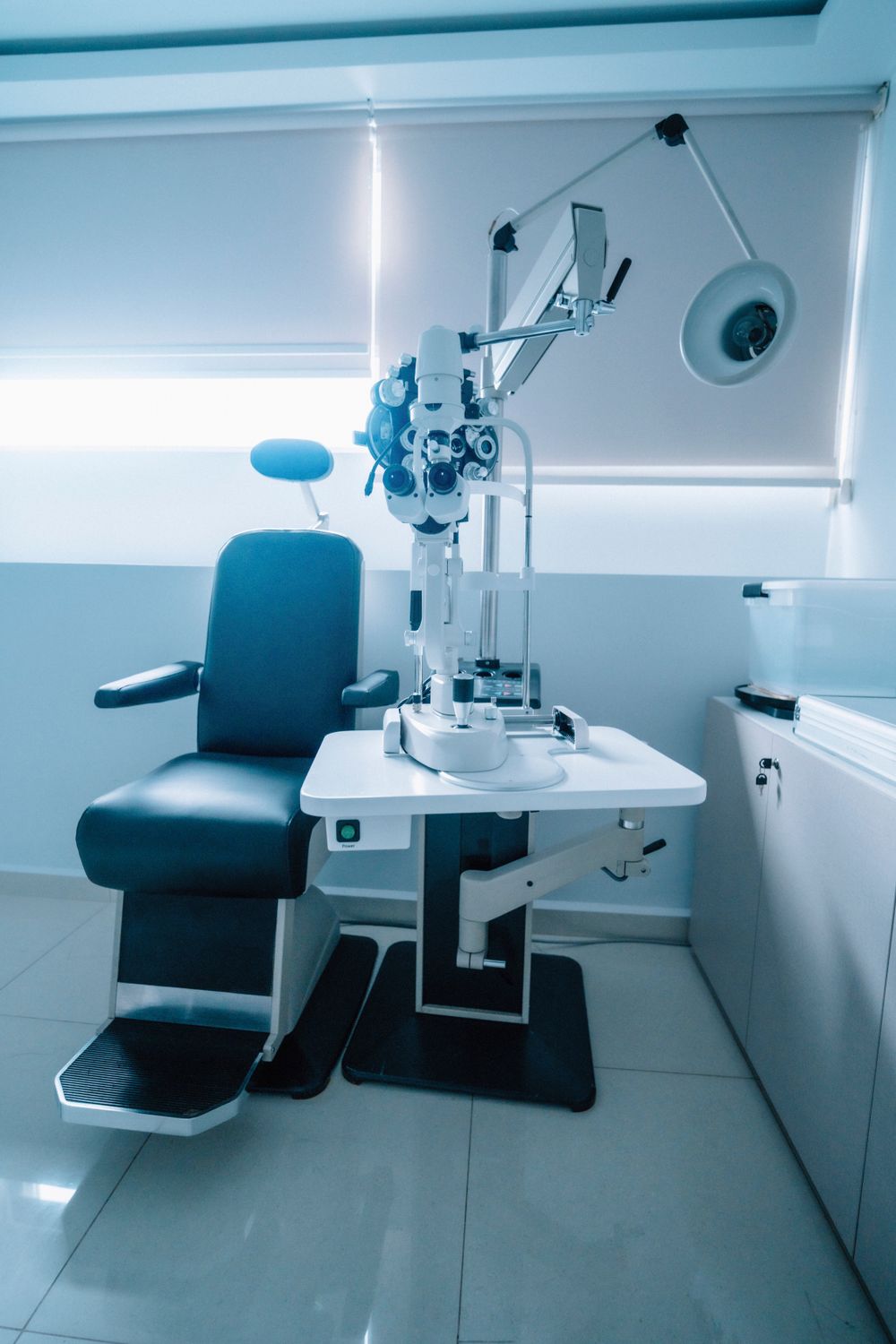 An eye examination room with a slit lamp and patient chair
