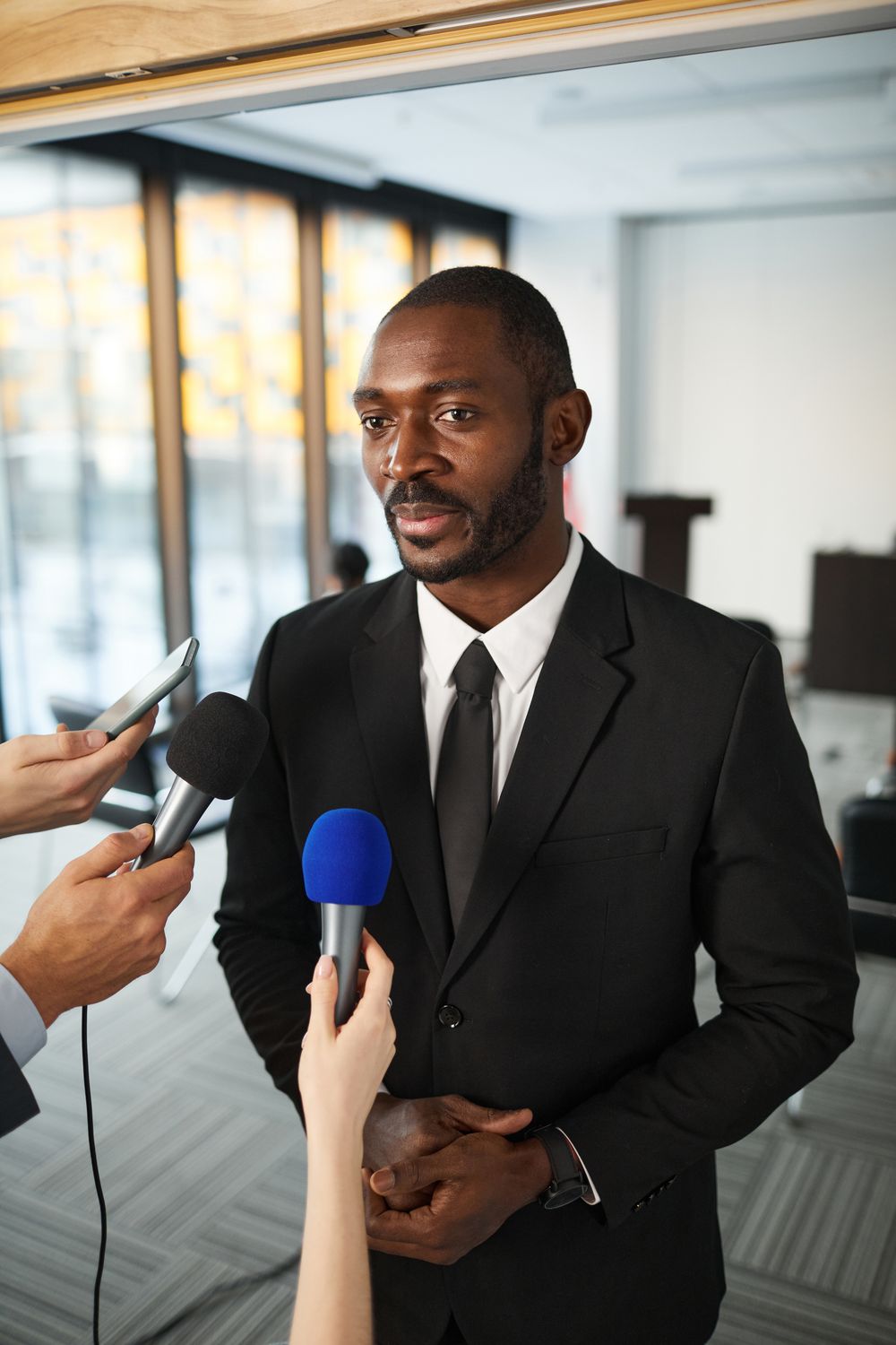 A reporter holding a microphone during a doorstep interview