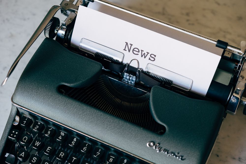 A vintage typewriter with a sheet of paper reading News