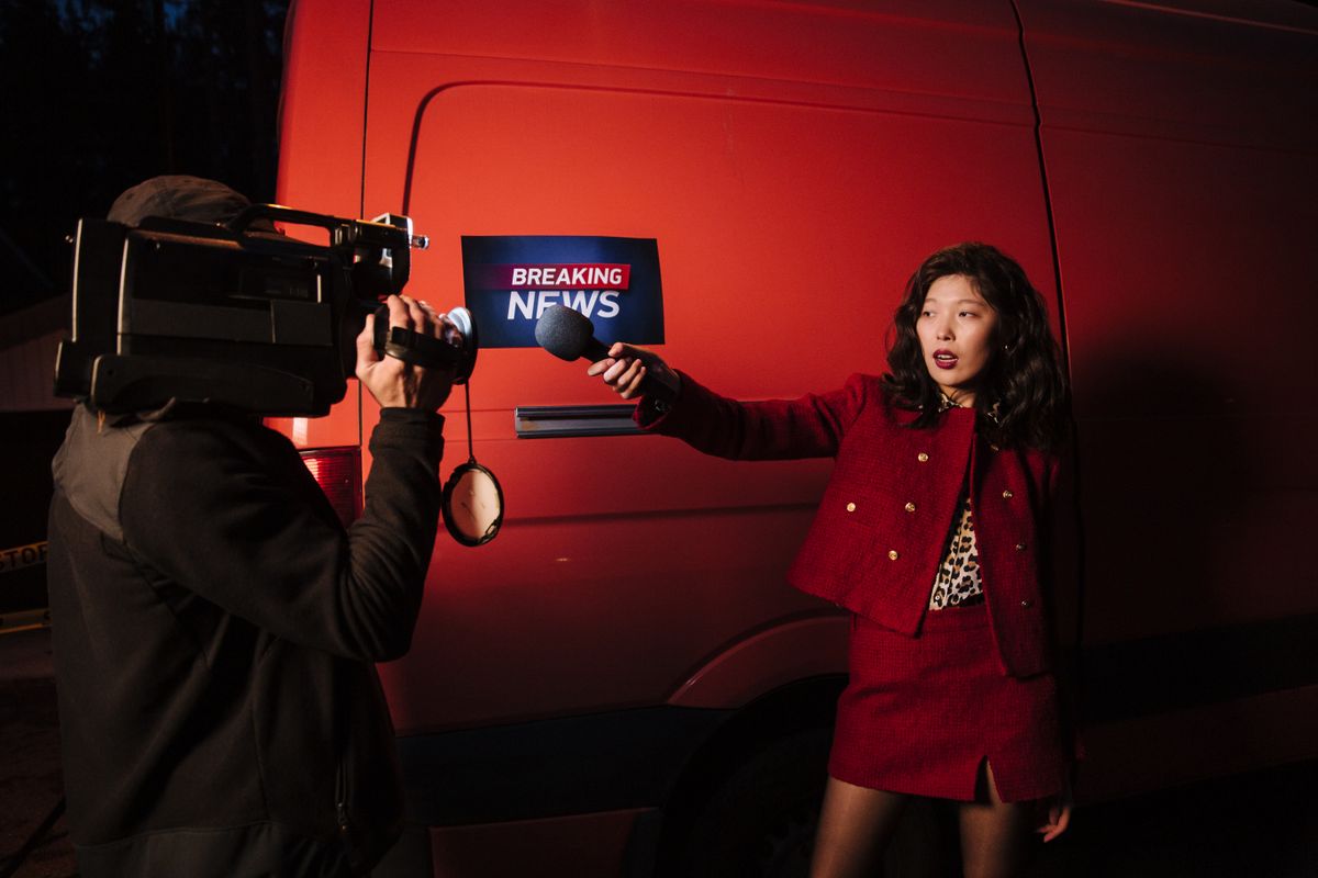 A reporter and camera operator filming a breaking news segment