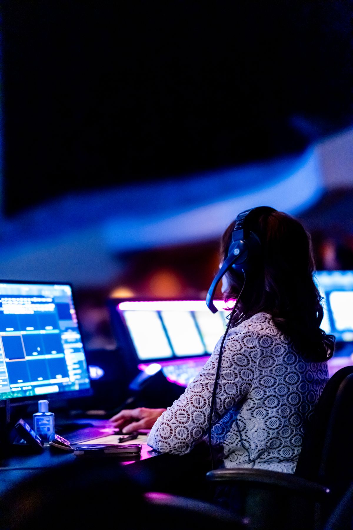 A journalist monitoring multiple news screens in a control room