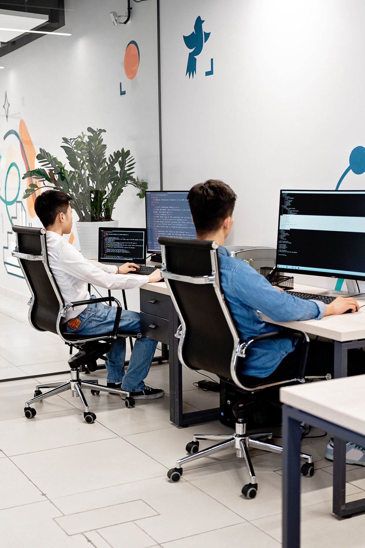 Two developers reviewing code together on a monitor