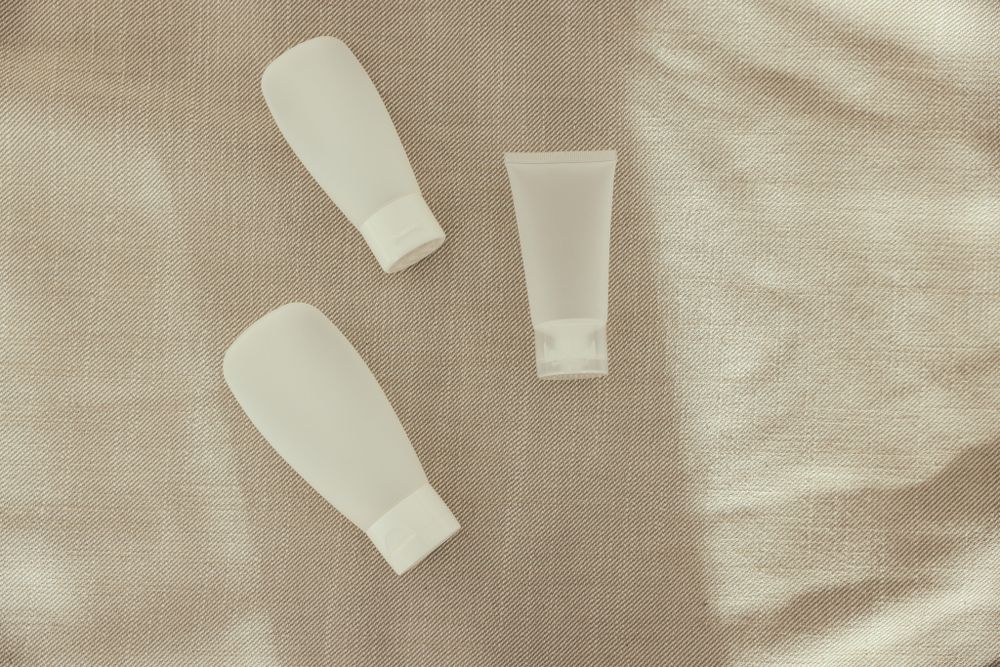 Cream-colored refillable bottles on natural linen