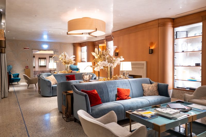 A relaxed hotel lounge with grey sofas and warm lighting