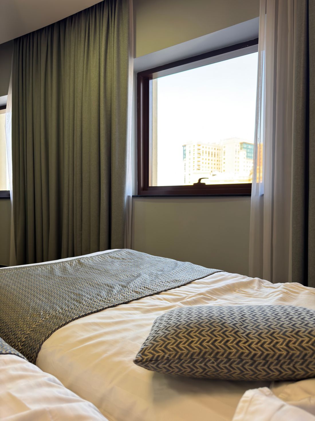 A quiet room with a window, folded throw and textured cushion