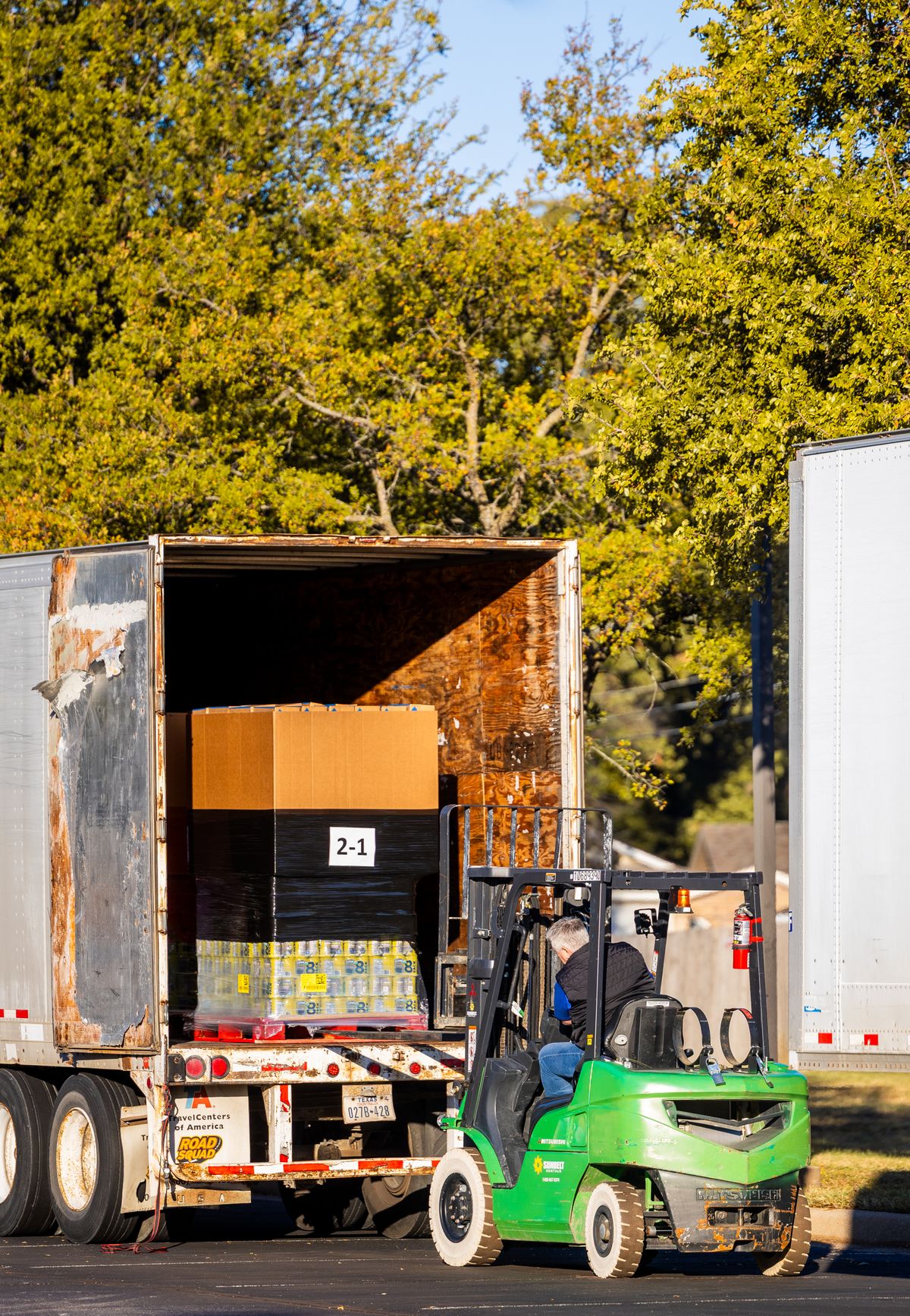 A forklift loading pallets of goods into a truck
