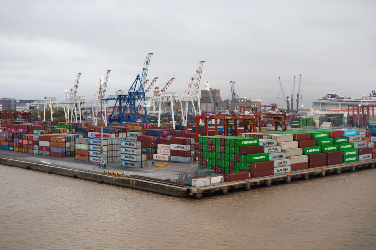A busy container port with stacked cargo at dusk