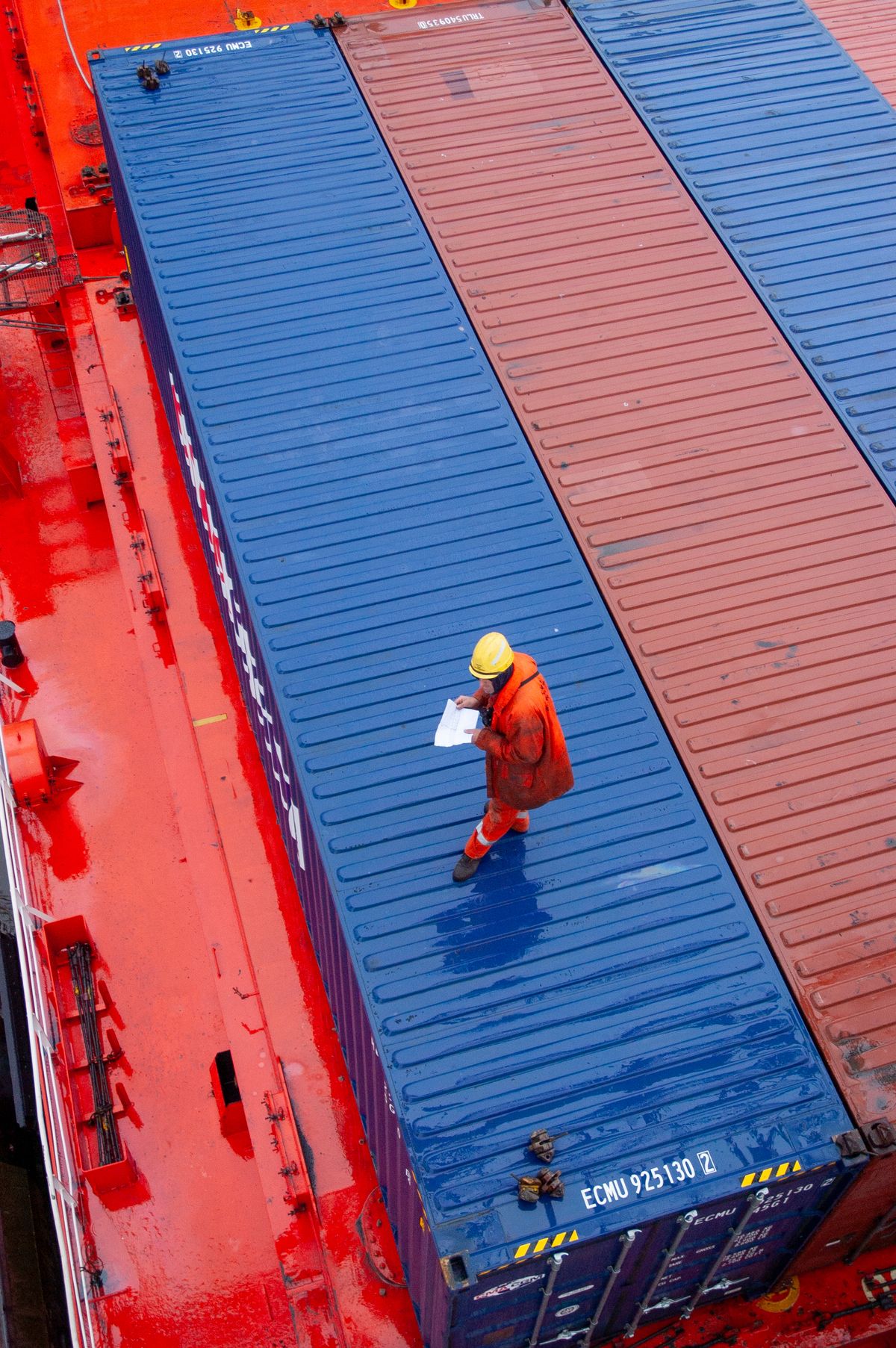 A port worker inspecting a shipping container being loaded